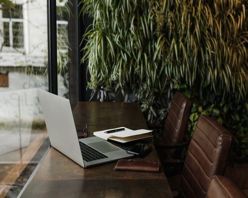 A well-organized personal workspace near a window with natural plants reflecting a calm day planning